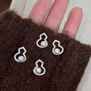 Boucles d'oreilles Hulu avec pavé de zircons et perles en or et argent sur la main
