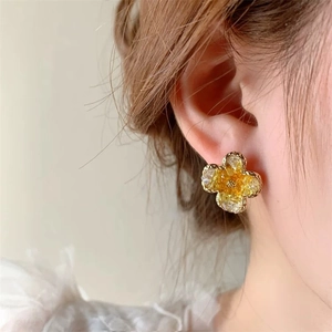 Close-up of a gradient crystal clover stud earring featuring delicate gold bead edges