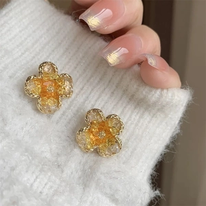 Elegant gradient crystal flower stud earrings with gold plating on a cozy knit background