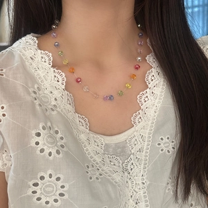 Collier de perles de citrouille colorées sur mannequin avec haut en dentelle blanche