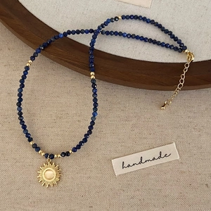 Detailansicht der handgefertigten Lapislazuli-Halskette mit goldenem Sonnenanhänger