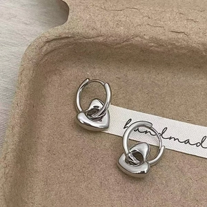 Detail of silver heart earrings with lava texture on handmade jewelry card