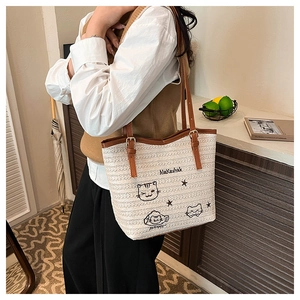 Détail du grand sac cabas tissé avec illustrations de chats noirs et anses en cuir marron
