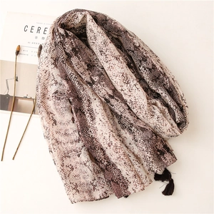 Snake print soft scarf with black fringe tassels displayed on a minimalist white backdrop