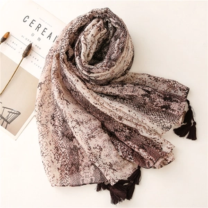 Detail of snake print scarf with pink and brown tones and elegant fringe tassels