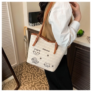 Détail du sac cabas tissé avec broderie chat et bandoulières en cuir marron réglables