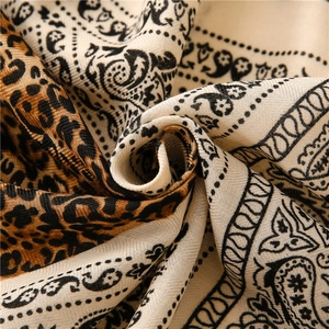 Macro detail of scarf featuring paisley and leopard print with soft linen feel texture