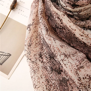 Close-up of soft snake print scarf with lightweight translucent fabric and pleated texture