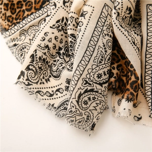 Detail of paisley and leopard print scarf showing soft twill texture and frayed edges