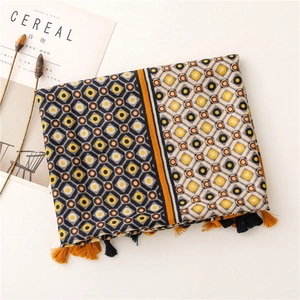 Detail of yellow and grey geometric honeycomb pattern scarf with fine fringe tassels