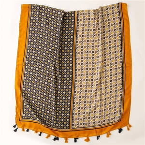Detail of bohemian geometric print scarf featuring yellow and black fringe tassels