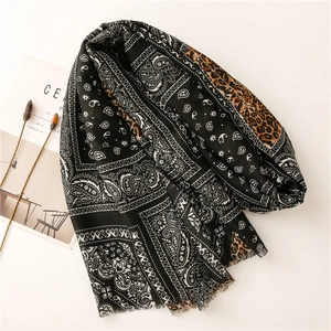 Detail of soft scarf featuring paisley and leopard print with delicate frayed edges
