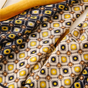 Detail of linen-feel scarf showing geometric diamond patterns and woven texture