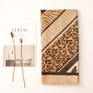 Détail d'une écharpe imprimé léopard et zèbre avec franges, style esthétique épuré