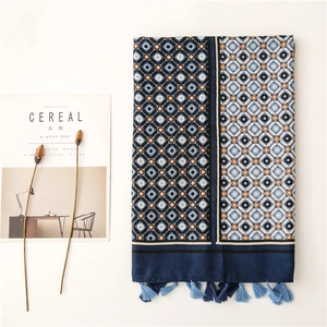 Detail of geometric rhombus pattern scarf with blue tassels and aesthetic props