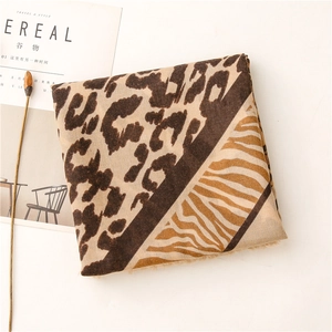 Détail de l'écharpe aux motifs léopard et zèbre avec des bords à franges délicates