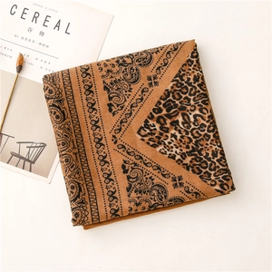 Close-up of linen-feel shawl with leopard and paisley print on minimalist background