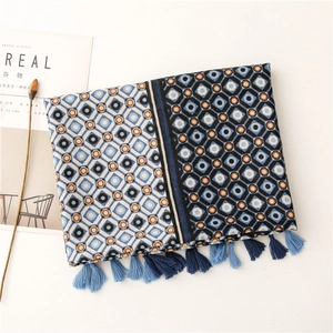 Detail of blue and brown geometric linen scarf featuring fringe tassels and herringbone weave