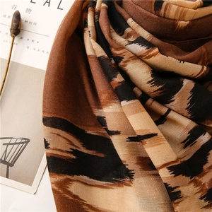 Detalle de bufanda con estampado de leopardo y textura suave sobre una revista