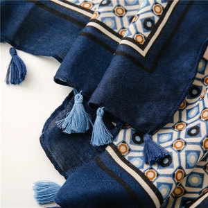 Detail of navy blue scarf with geometric pattern, fringe edges and twill texture