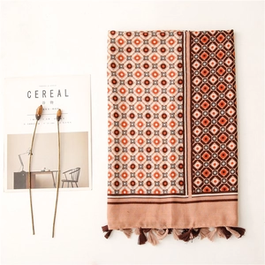 Flat lay of linen-feel scarf with geometric prints and fringe on a magazine
