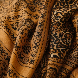 Macro detail of paisley and leopard print texture on cotton-linen feel pashmina scarf