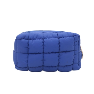 Blue quilted makeup bag featuring a square puffer design with a durable metal zipper