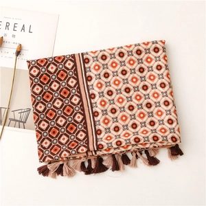 Detail of geometric pattern scarf with orange tassels and bohemian print texture