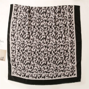 Détail d'écharpe douce imprimé camouflage léopard avec bordure noire et franges