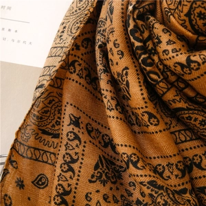 Detail of caramel paisley scarf showing fine twill weave texture and boho patterns