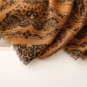 Macro detail of mustard yellow herringbone scarf with paisley and leopard prints