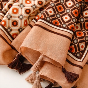 Detail of geometric rhombus pattern and long tassels on soft herringbone weave shawl