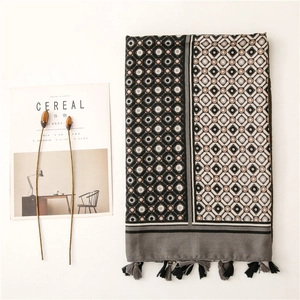 Detail of soft cotton-linen scarf with geometric diamond prints and black tassel fringe