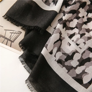 Détail d'une écharpe en coton et lin avec motif léopard noir et blanc et bords effilochés