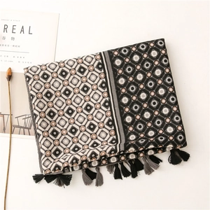 Detailed view of geometric diamond pattern scarf with long black and grey tassels