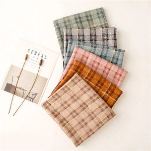 Macro detail of six assorted plaid scarves showing soft texture and fringe edges