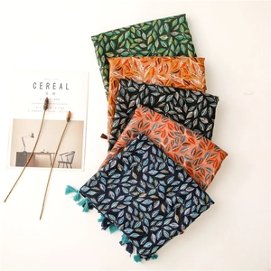 Détail de foulards à motif de feuilles avec franges en plusieurs couleurs effet coton