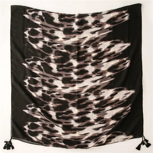 Detalle de bufanda con estampado de leopardo, flecos negros y textura de tela ligera