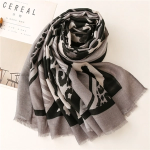Détail d'un châle gris imprimé léopard avec franges et carte décorative