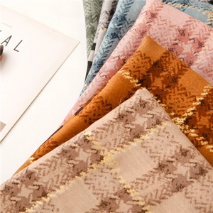 Detailed texture of cotton linen scarves with gold thread lattice and herringbone patterns