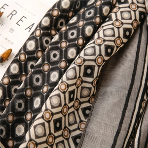 Detail of geometric pattern linen-feel scarf with herringbone texture and soft draping