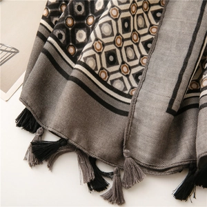 Detail of geometric pattern scarf with twill texture and long grey fringes edges