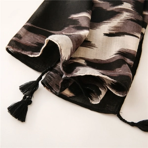 Detalle de bufanda con estampado de leopardo, flecos negros largos y textura fina