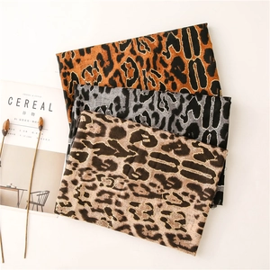 Macro shot of three cotton-feel leopard print scarves with gold foil chevron texture details