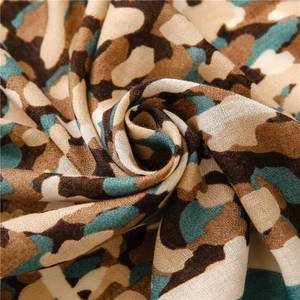 Gros plan du tissu de l'écharpe en coton camouflage montrant la texture et les tons terre