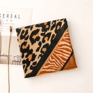 Détail d'écharpe avec imprimé léopard et tigre, bords effilés doux et motifs variés