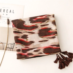 Detalle de chal suave con estampado de leopardo y flecos, tonos marrón, beige y rojo