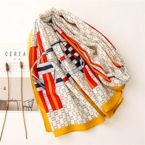 Detail of colorful long scarf with interlaced G pattern and elegant rolled edges