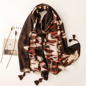 Chal largo de estilo étnico con flecos marrones y patrones estampados abstractos