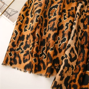 Detail of leopard print scarf with gold foil accents and soft fringe texture